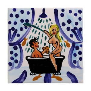 Pode incluir: Azulejo cerâmico quadrado com uma ilustração lúdica de um casal a tomar banho. A obra de arte retrata uma pessoa numa banheira a ser ensaboada por outra pessoa. O azulejo tem um fundo branco com detalhes em azul e laranja.