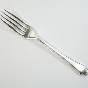 May include: A silver fork with a simple, elegant design. The fork has four tines and a slightly curved handle.