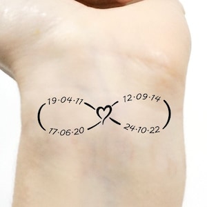 May include: A black infinity symbol tattoo with four dates inside the loop: 19-04-77, 12-09-14, 17-06-20, and 24-10-22. The symbol is drawn on a person's wrist.
