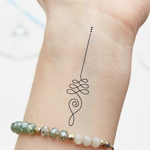 May include: A black temporary tattoo of a simple line design with a spiral at the bottom on a person's wrist.