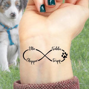 May include: A black infinity symbol tattoo with the names "Ellie", "Chipper", "Teddie", and "Tripp" and a paw print. The tattoo is on a person's wrist.