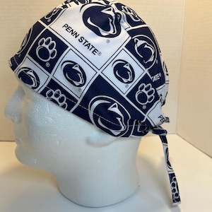 Peut inclure: Un bonnet de chirurgien bleu et blanc à motifs avec le logo du lion Nittany de Penn State et le texte "Penn State" répété sur tout le design.