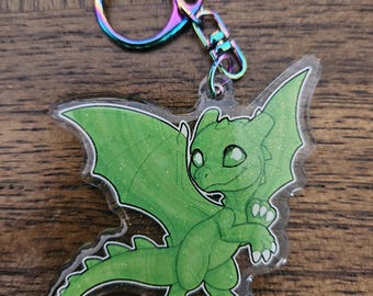 May include: A green glitter dragon keychain with iridescent metal key ring. The dragon has wings, a tail, and a cute expression.