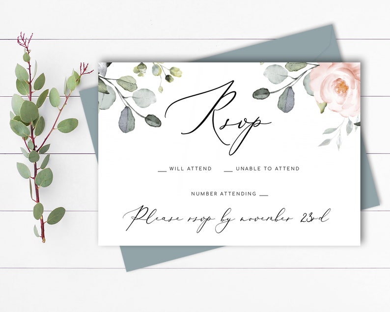 May include: A white RSVP card with a floral design featuring pink roses and eucalyptus leaves. The text "RSVP" is written in cursive script. The card includes lines for guests to indicate whether they will attend, unable to attend, and the number attending. The card also includes the text "Please RSVP by November 23rd."