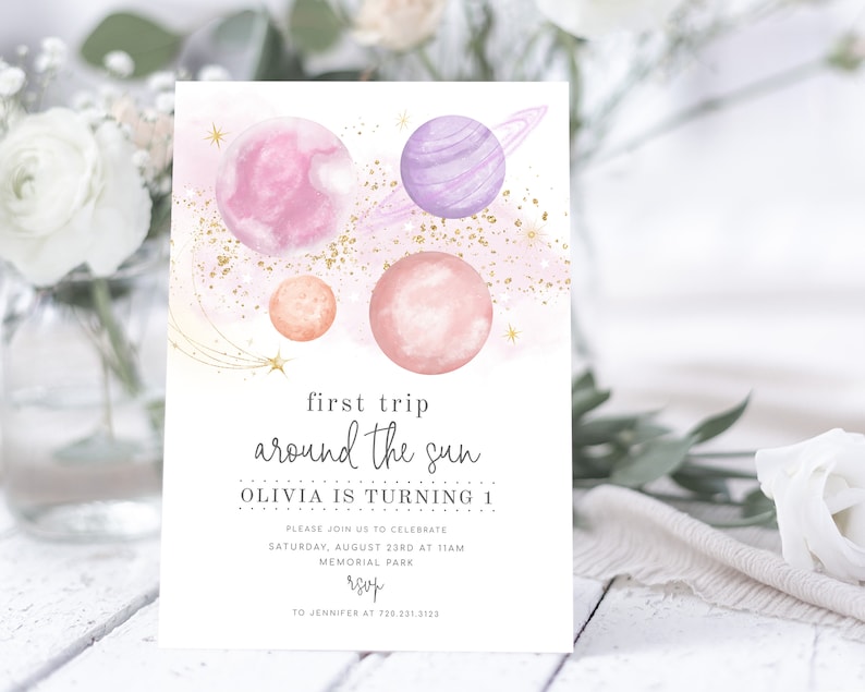May include: A pink and purple watercolour illustration of planets and stars with gold glitter. The text reads "first trip around the sun Olivia is turning 1 Please join us to celebrate Saturday, August 23rd at 11am Memorial Park rsvp to Jennifer at 730.231.3123"