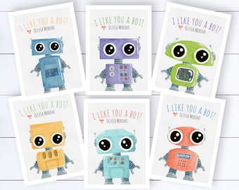 May include: Six printable cards featuring a robot with the text "I like you a bot!" and the name Olivia Moreno. The robots are different colors: blue, purple, green, yellow, turquoise, and orange.