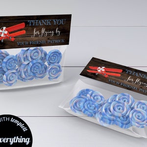 May include: Thank you for flying by your friend, Patrick.  A red airplane with a propeller is on a brown wood background.  The thank you tag is in a clear cellophane bag with blue and white swirl candies.