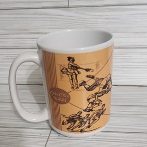 May include: White ceramic mug with a brown handle. The mug features a vintage illustration of people playing various sports, including baseball, lacrosse, and ice skating. The text "Pee Chee All Season Portfolio" is printed on the mug.