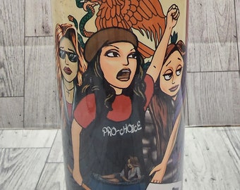 May include: A white tumbler with a graphic of three women with a Mexican eagle and the words "Chicana" and "Pro-Choice 1973" printed on it.