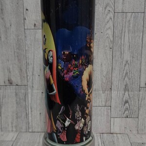 Puede incluir: Un vaso de acero inoxidable con fondo negro y una imagen colorida de personajes de la pel&iacute;cula "Pesadilla antes de Navidad".