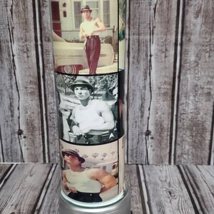 May include: A stainless steel tumbler with a silver base. The tumbler features a collage of images of a man wearing a white tank top and a hat. The images are in black and white and color.