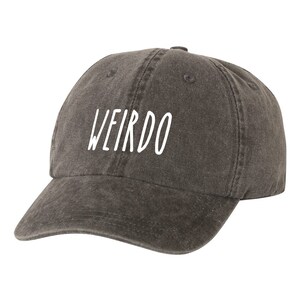 May include: A dark gray baseball cap with the word "WEIRDO" embroidered in white on the front.