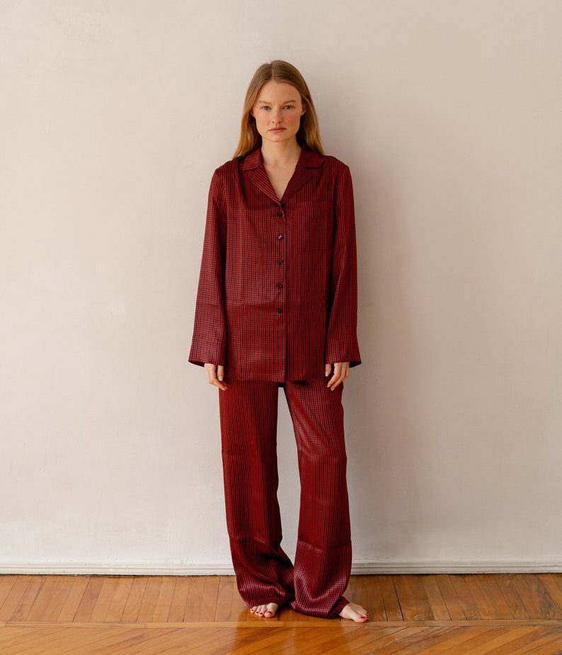 May include: A red and black checked pyjama set with a collared shirt and long trousers.