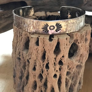 A handmade, hand stamped sterling silver cuff bracelet. A cross between southwest & modern designs. Made in the USA. Heavy duty.