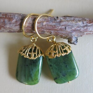 K&ouml;nnte beinhalten: Ein Paar gr&uuml;ne Jade-Ohrringe mit goldenen Filigran-Akzenten. Die Ohrringe sind rechteckig und haben ein zartes, filigranes Design.