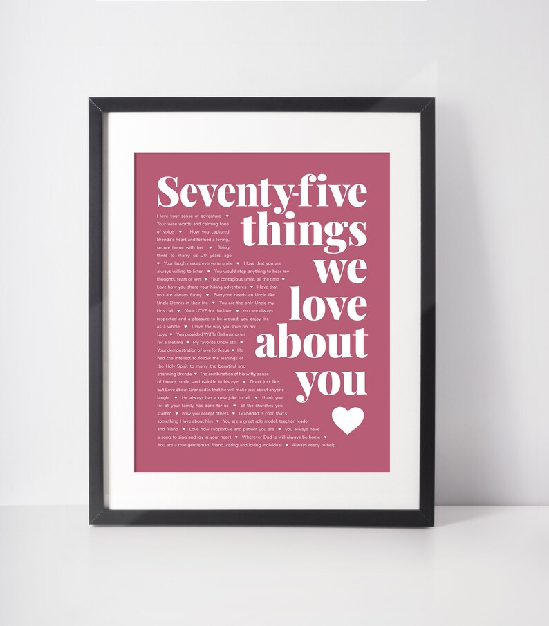 May include: Framed print with a white background and a dark pink design. The text reads "Seventy-five things we love about you" with a white heart. The print is in a black frame.