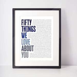 May include: Framed print with the words "FIFTY THINGS WE LOVE ABOUT YOU" in a navy and light blue font. The text is surrounded by a black frame and includes a list of loving sentiments.