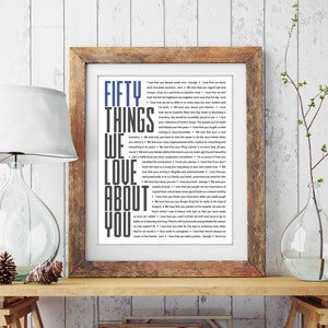 May include: A framed print with a white background and black text that reads "Fifty Things We Love About You". The frame is brown wood with a white mat.