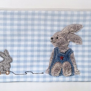 Embroidery file rabbit boy sitting with pull-along rabbit