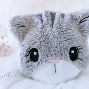 May include: A plush gray cat head with embroidered black eyes, white pupils, and a pink nose.