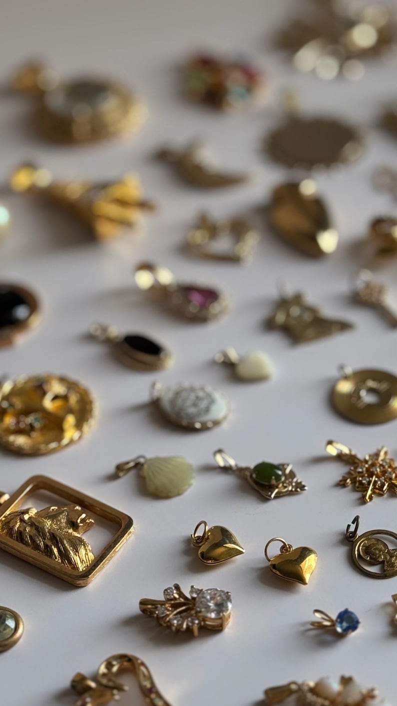 Vintage pendants and charms in a mix of gold tone, gold filled and stainless steel metals. Rhinestones, diamonds, pearls, jade and tigers eye.