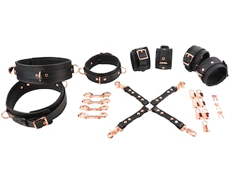 Conjunto de ataduras de cuero negro de lujo con herrajes en oro rosa: collar, esposas para muñecas, tobillos y muslos, conector, broches y candados.