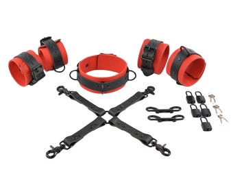 Conjunto de ataduras de cuero rojo de lujo con herrajes negros: collar, esposas para muñecas y tobillos, conector cruzado, mosquetones y candados.