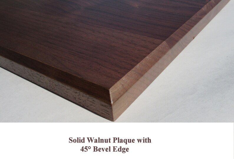 May include: Close-up of a solid walnut plaque with a 45-degree beveled edge. The wood has a rich brown color and a smooth finish.