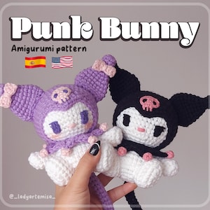Puede incluir: Dos peluches amigurumi de crochet, uno morado y otro negro, con detalles blancos. Ambos peluches tienen un diseño de calavera en la cabeza y sostienen lazos rosas. Los peluches están sentados en una mano, y la leyenda "Punk Bunny Amigurumi pattern" es visible en la parte superior de la imagen.
