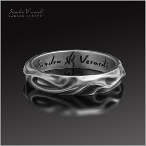 Puede incluir: Un anillo de plata con una superficie texturizada y ondulada. El interior del anillo est&aacute; grabado con las palabras "Sandro Verardi".