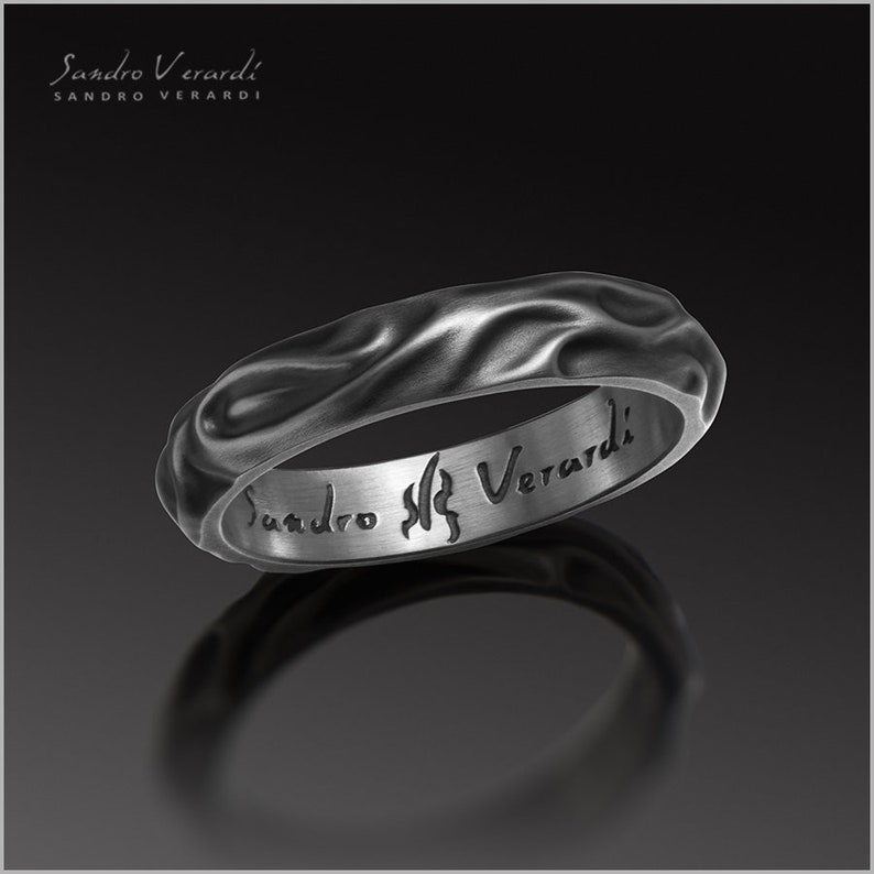 Puede incluir: Un anillo de plata con un dise&ntilde;o texturizado y ondulado. El interior del anillo est&aacute; grabado con las palabras "Sandro Verardi".