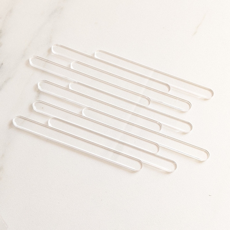May include: Ten clear acrylic rods, arranged in a staggered pattern on a white surface. The rods are approximately 10 inches long and 1/2 inch in diameter.