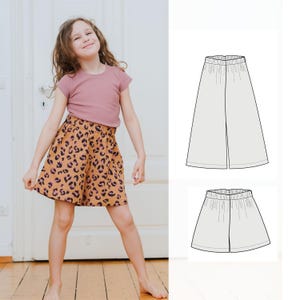May include: A young girl wearing a mauve t-shirt and a skirt with a leopard print design. The skirt is a warm tan color with dark brown spots. The image also includes technical drawings of a pair of wide-leg pants and a skirt.