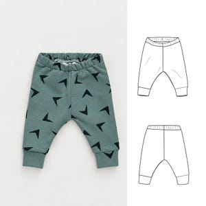 May include: Sage green pants featuring a repeating black chevron pattern, an elasticized waistband, and cuffed ankles. The image includes a technical line drawing showing the front and back views of the pants with a gathered waist and cuffs.