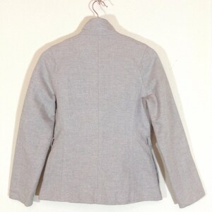 May include: A grey blazer with a stand-up collar and long sleeves.