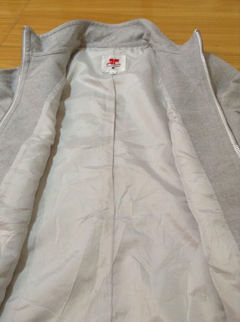 May include: A grey zipped jacket with a white lining. The jacket has a red label with the text "SOUTHPOLE" on it.