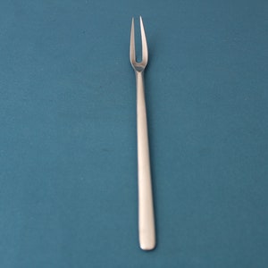 May include: A silver fork with two prongs on a blue background.