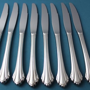 May include: Eight silver dinner knives with ornate handles.