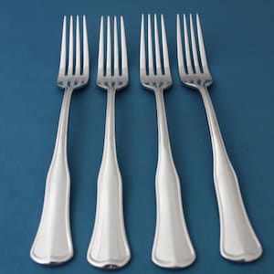 May include: Four silver forks with a polished finish and a slightly curved handle.