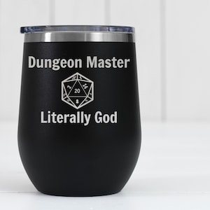 Könnte beinhalten: Schwarzer Edelstahl-Weinglas mit einer weißen Aufschrift "Dungeon Master Literally God" und einer Grafik eines 20-seitigen Würfels.