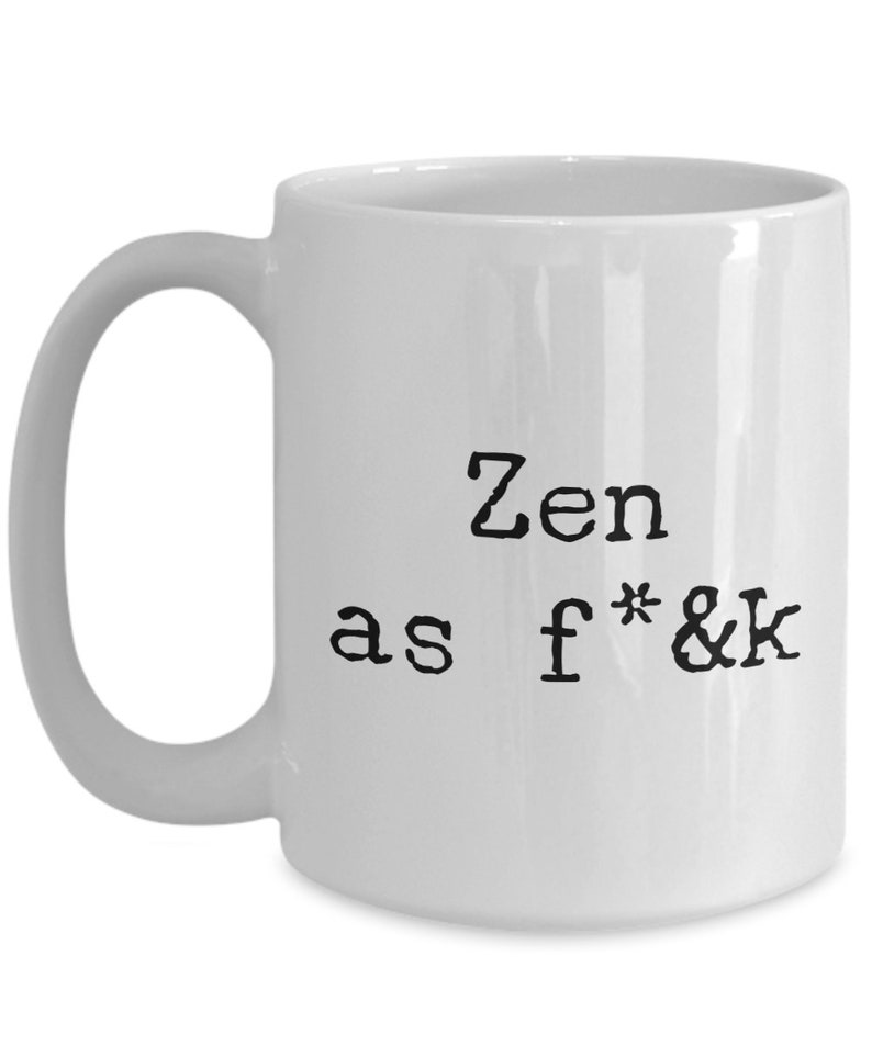 May include: White ceramic mug with a black handle. The mug features the text "Zen as f*&k" in a bold, typewriter-style font. The design is centered on the mug's surface.
