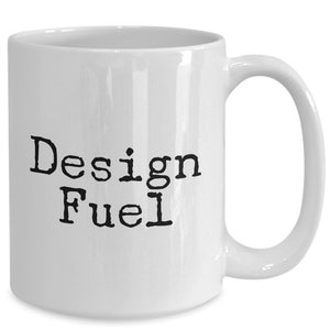 May include: White ceramic coffee mug with black text that reads "Design Fuel".