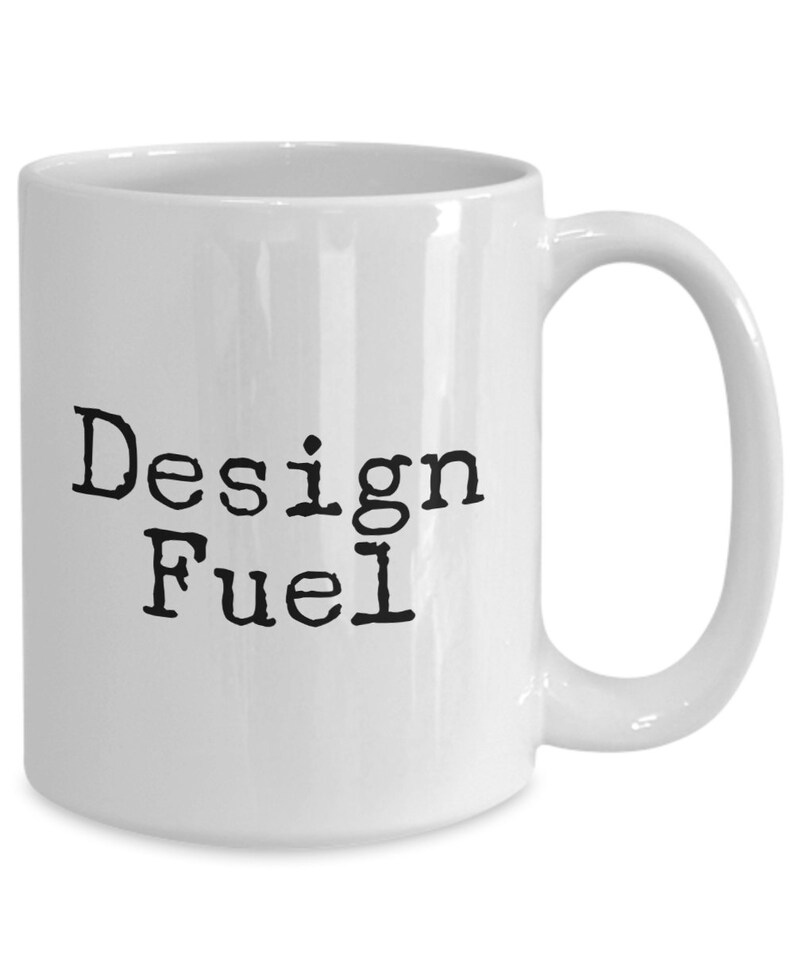 May include: White ceramic coffee mug with black text that reads "Design Fuel".