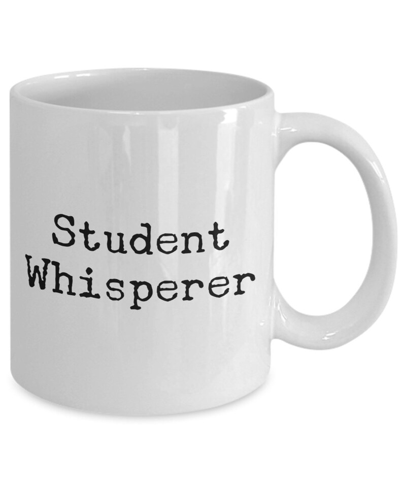 May include: White ceramic coffee mug with black text that reads "Student Whisperer".