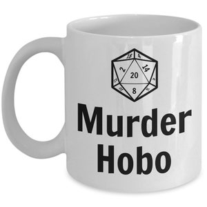 K&ouml;nnte beinhalten: Wei&szlig;e Keramiktasse mit einer Schwarzwei&szlig;illustration eines zwanzigseitigen W&uuml;rfels und dem Text "Murder Hobo".
