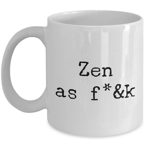 May include: White ceramic mug with a black text that reads "Zen as f*&k". The mug has a curved handle and a simple, clean design. Perfect for coffee, tea, or any favorite beverage.