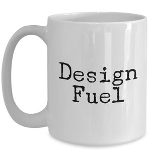 May include: White ceramic coffee mug with black text that reads "Design Fuel".