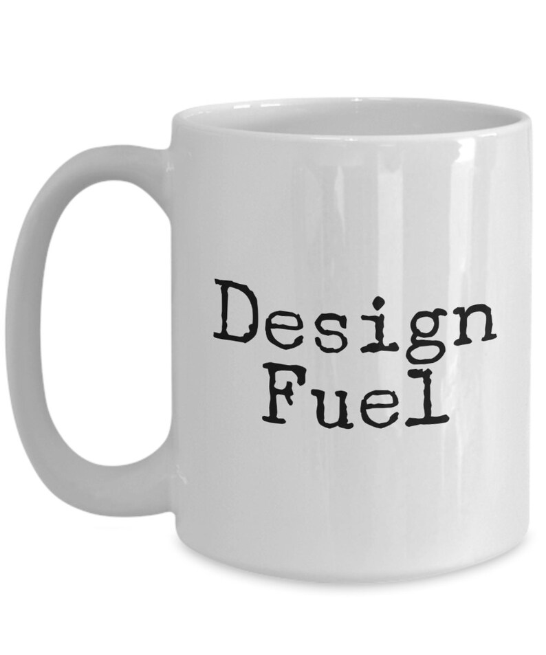 May include: White ceramic coffee mug with black text that reads "Design Fuel".