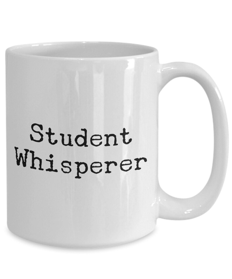 May include: White ceramic coffee mug with black text that reads "Student Whisperer".