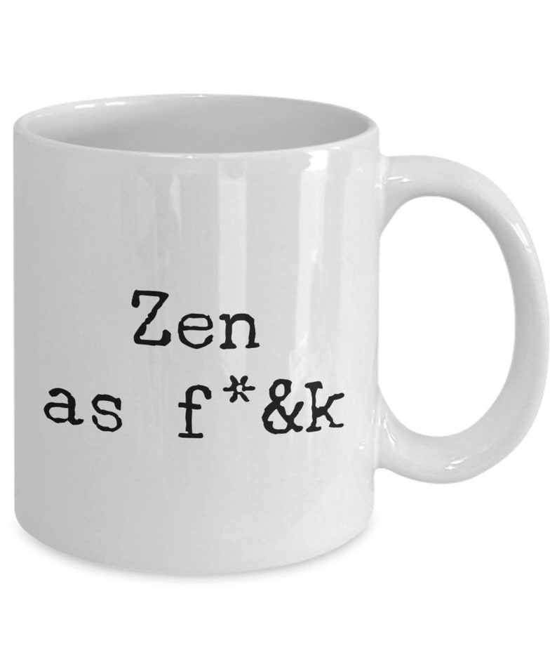 May include: White ceramic mug with a curved handle. The mug features the text "Zen as f*&k" in black, bold, sans-serif font. The mug is a standard size for coffee or tea.